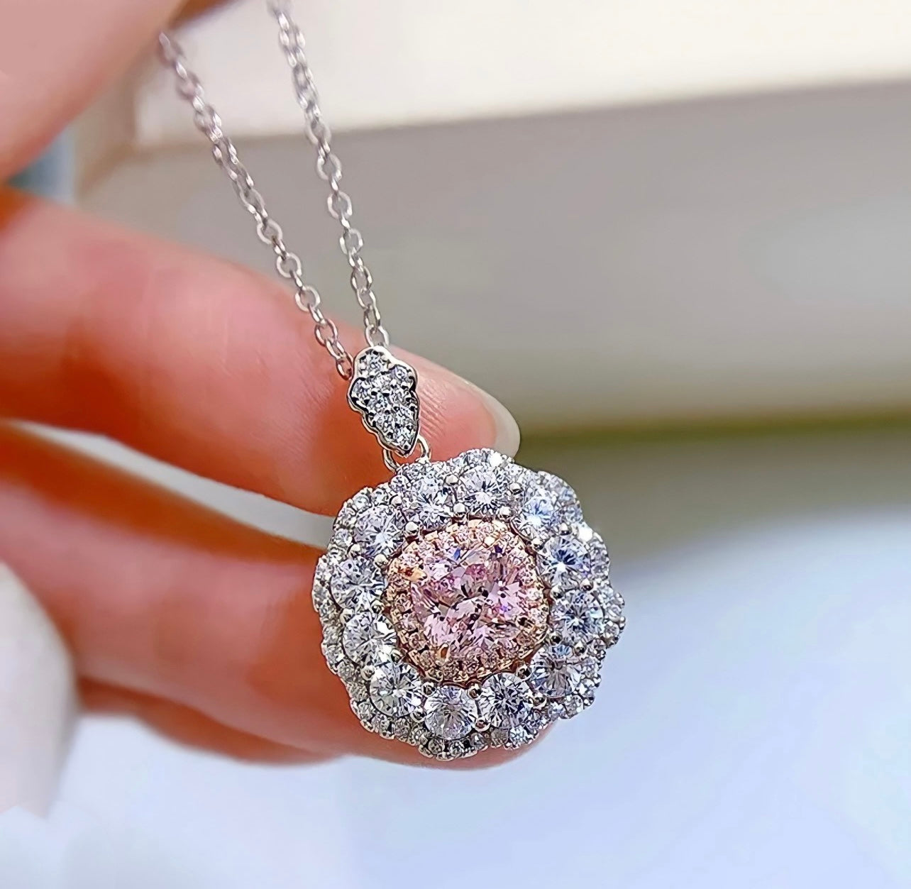 Cut Ice shaped simulated diamond necklace in pink stone color, crafted in sterling silver plated with 18k white gold with rhodium, necklace n woman hands, details of necklace